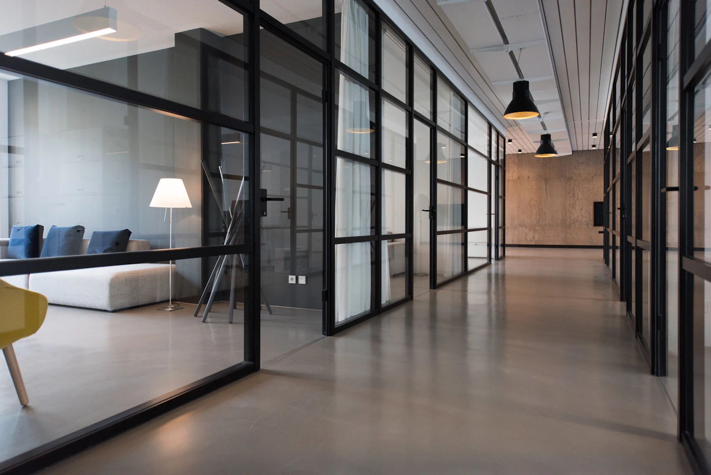 A bright, uncluttered building interior with glass partitions and natural light